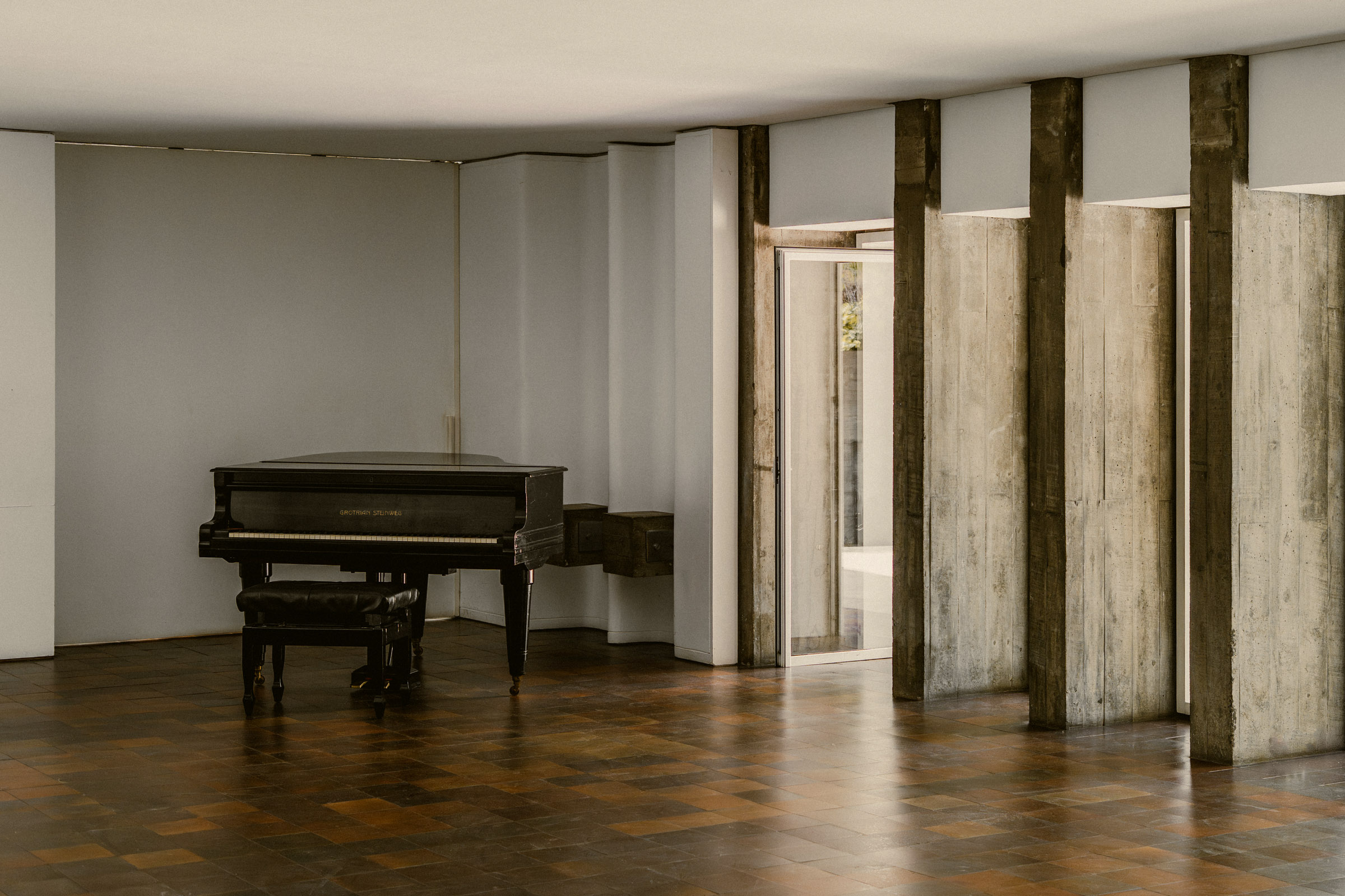Piano set against the sculptural concrete walls of Casa Carvajal.