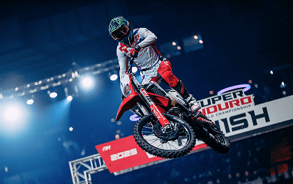 Motocrossowiec w powietrzu wykonujący akrobację na motocyklu terenowym podczas Mistrzostw Świata SuperEnduro.