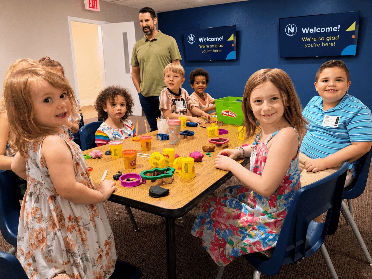 Children smiling during a Sunday classroom activity at New Hope Kids