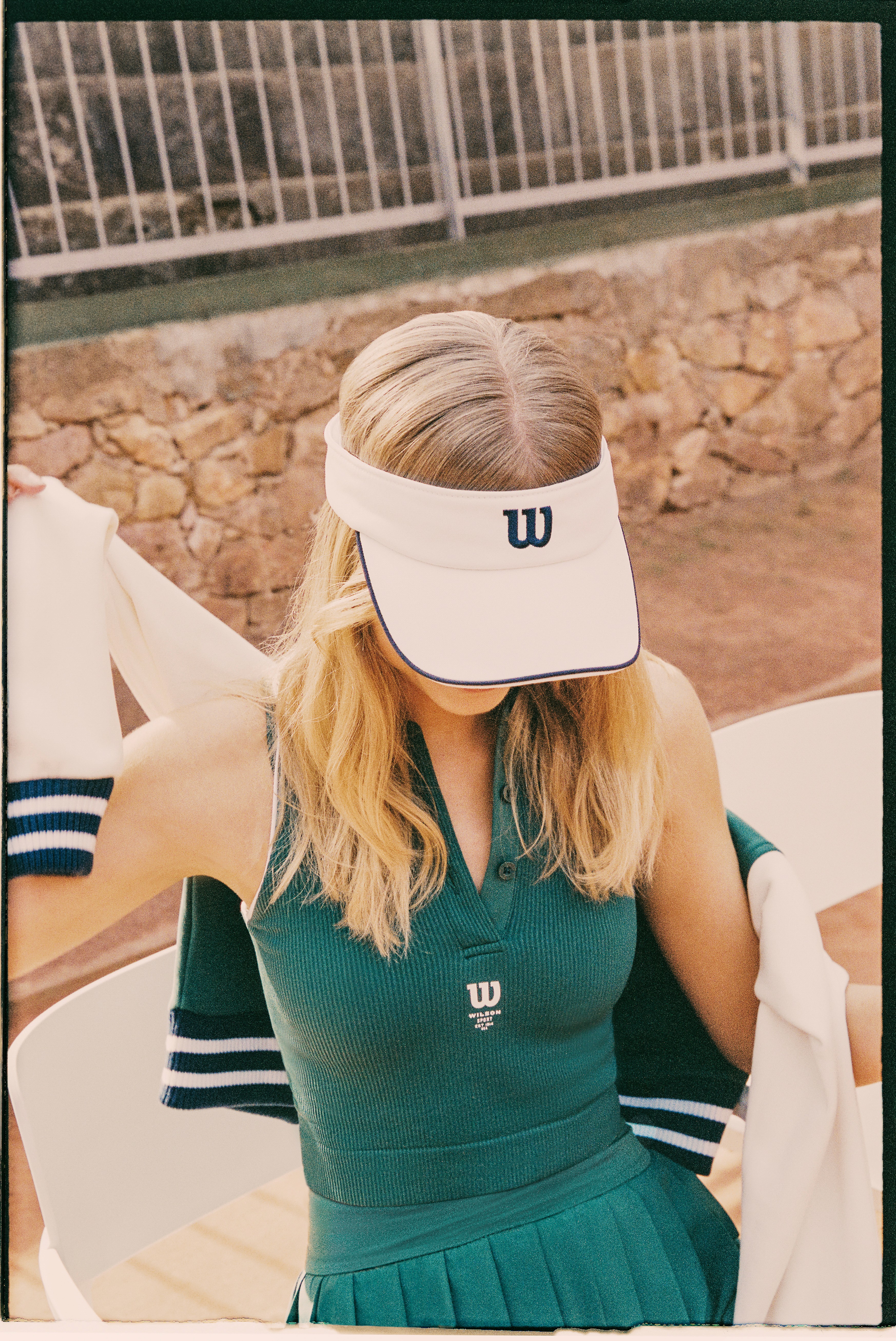 Focus sur la visière de tennis Wilson Sportstyle, portée avec une robe de tennis verte de la marque Wilson Courtstyle