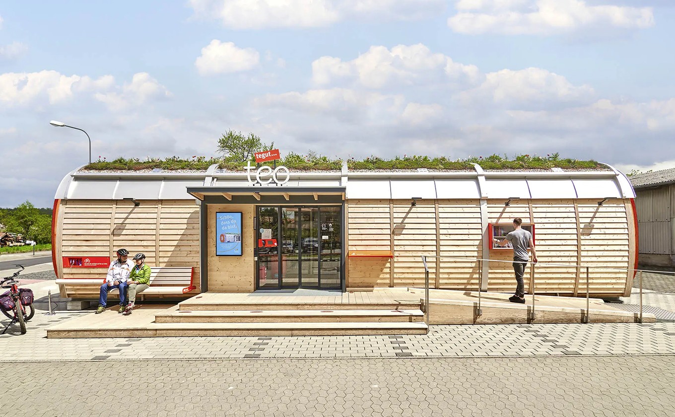 Frontansicht des tegut… teo in Rasdorf mit Kund:innen – nachhaltiges Micro-Store Konzept gestaltet von Design for Human Nature in Hamburg.