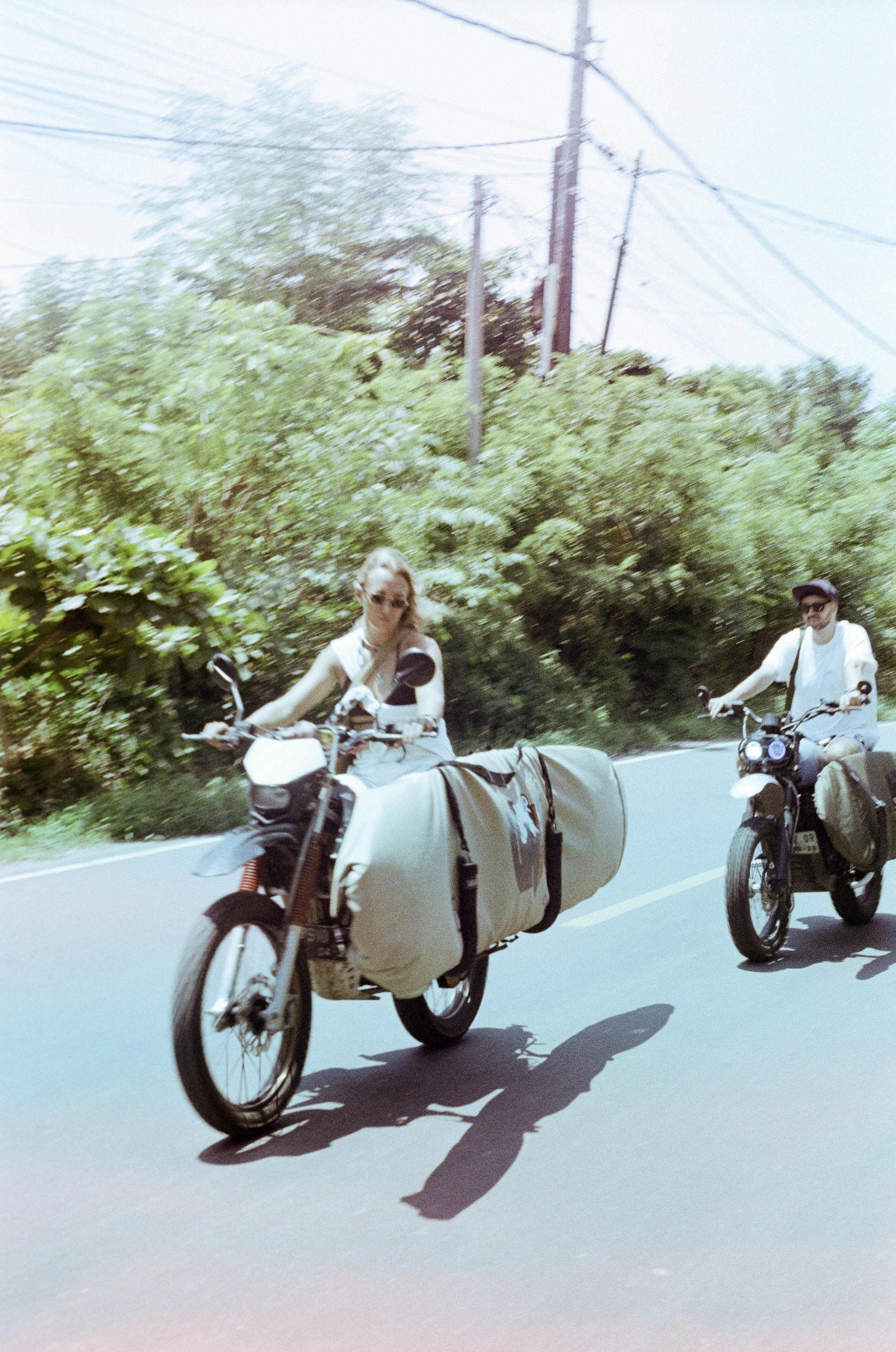 surfers driving with surfboards on their bikes in Bali, Uluwatu