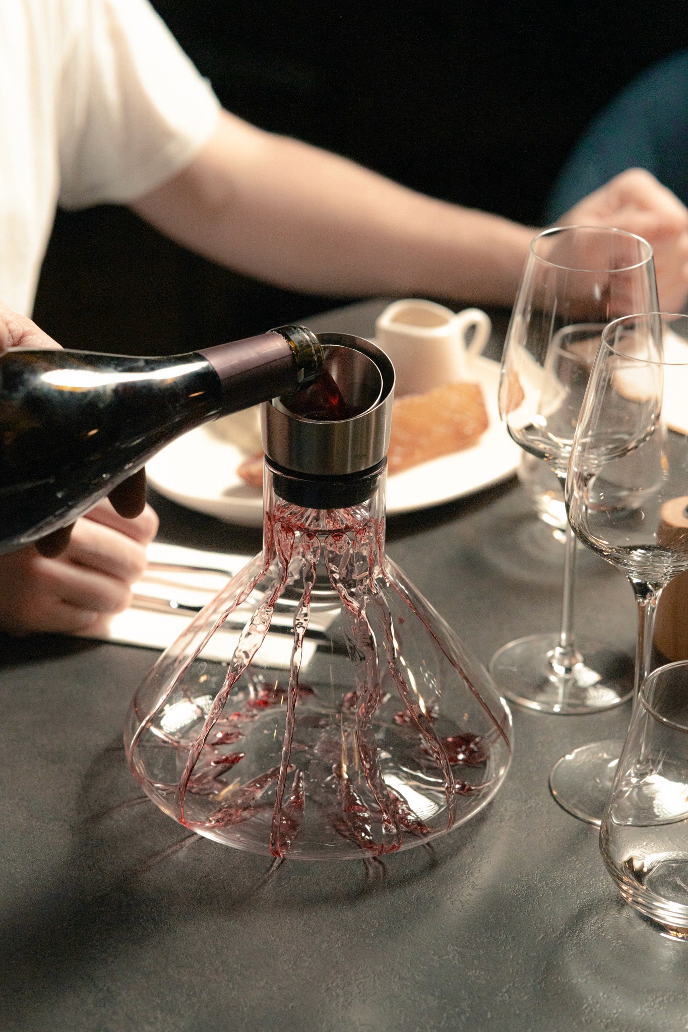 Service d’un vin rouge en carafe durant un repas, illustrant l’importance des accords mets et vins proposés par le restaurant à Vichy.