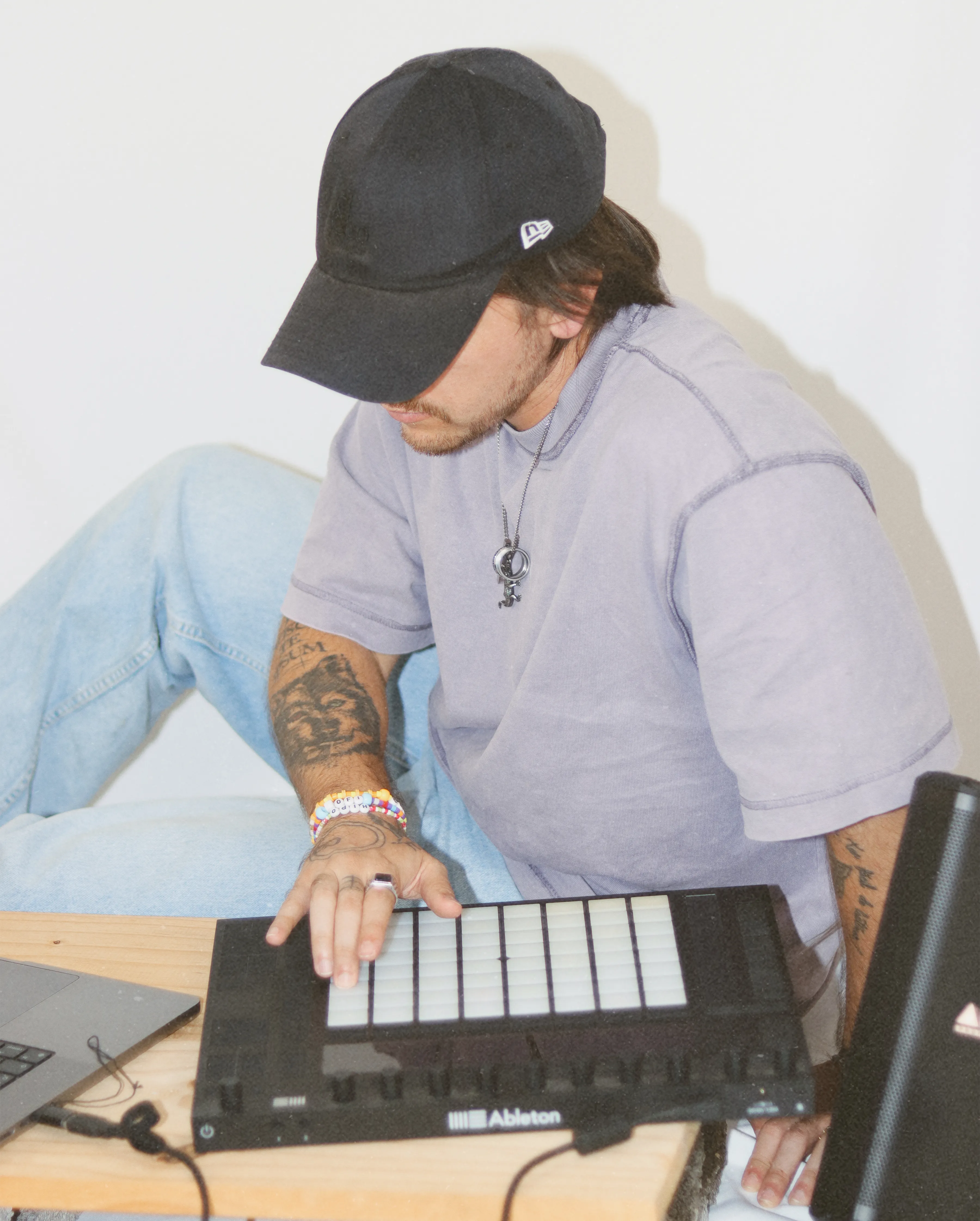 Músico concentrado produciendo música en laptop y controlador