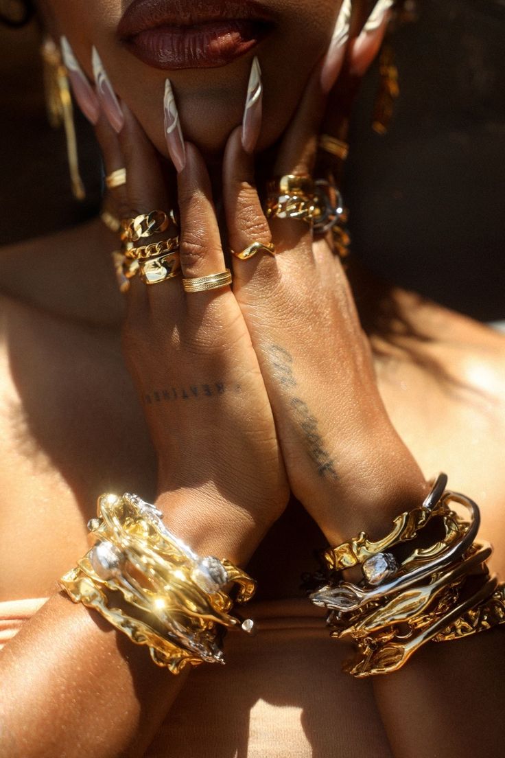 Man wearing olive green and orange sneakers with tall socks, standing on an urban street with a modern fence and skyscraper in the distance.