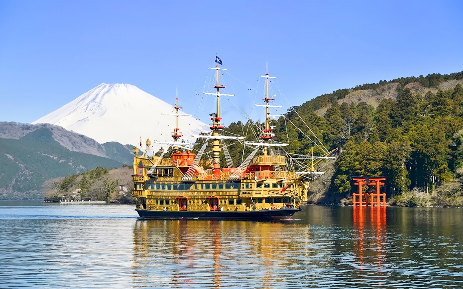 Hakone Free Pass users enjoying scenic view of Mount Fuji from a boat on Lake Ashi, Japan.