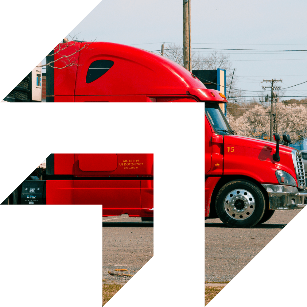 A red semi-truck parked on a lot under clear skies — representing startup trucking businesses preparing to get insured and hit the road with GIA Group, LLC.