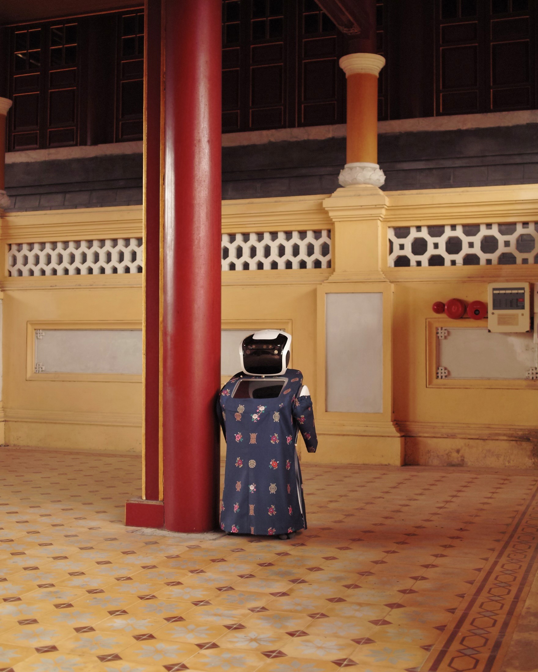 Photographie d'un robot humaoïde qui porte des habits traditionnels vietnamiens dans un temple traditionnel de la ville de Hue au Vietnam