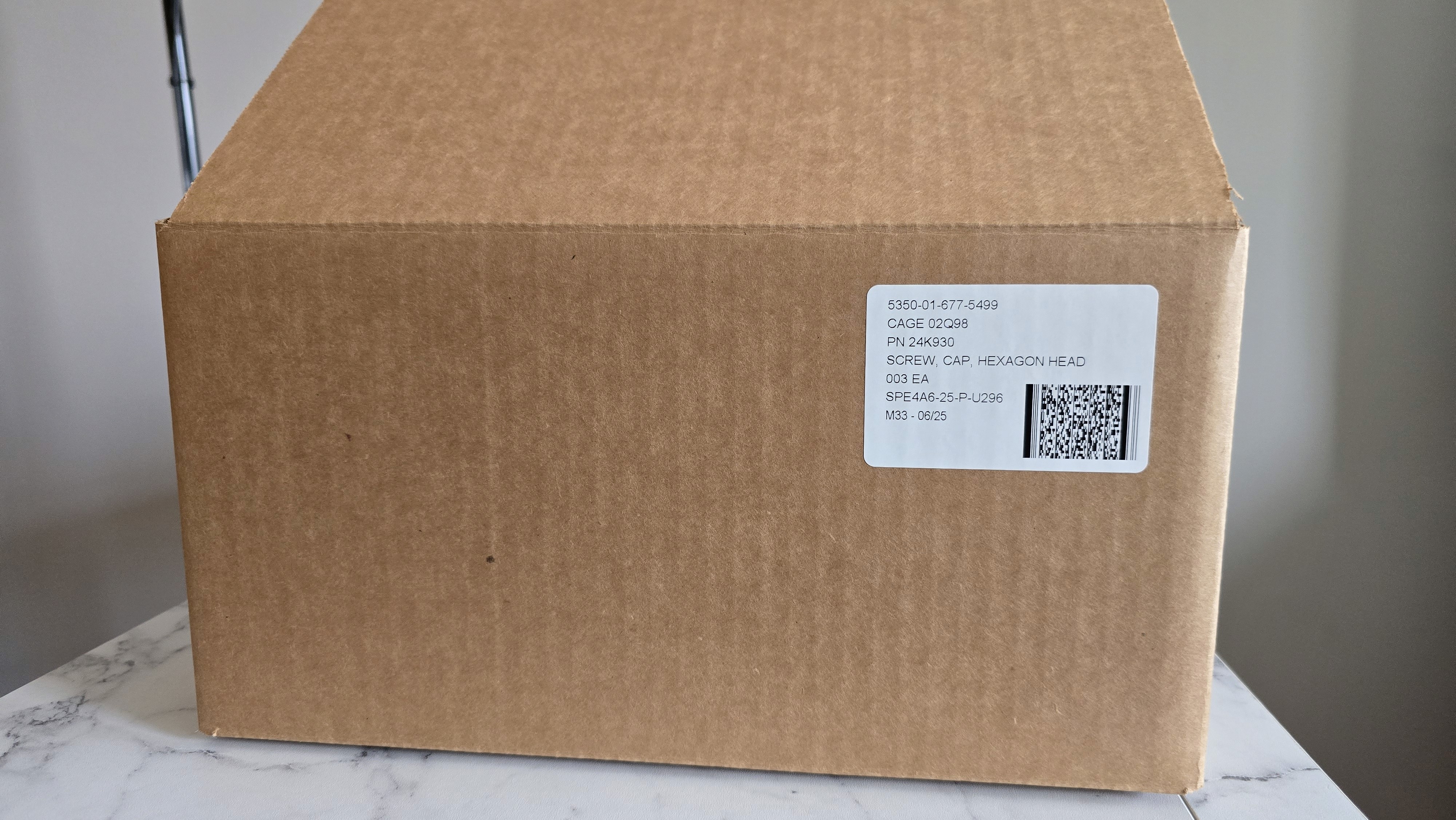 Smiling young man with short hair poses against a dark background, wearing a green button-up shirt.