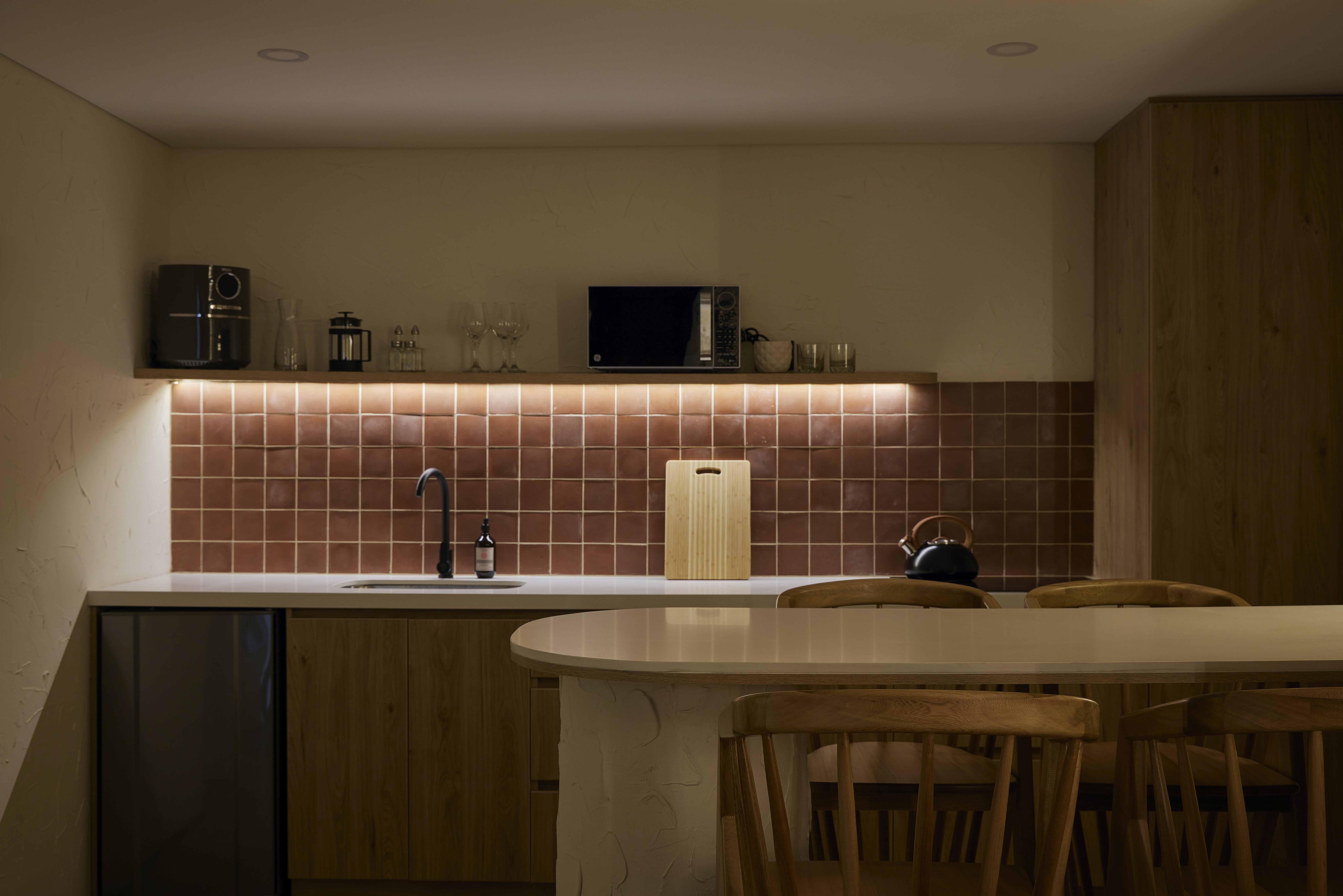 Double-height interior with flowing sculptural forms and warm raking light