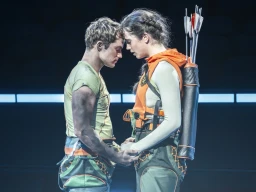 런던 무대에서 막을 올린 연극 '헝거 게임', 캣니스와 피타가 서로의 이마를 맞댄 채 맞잡은 두 손