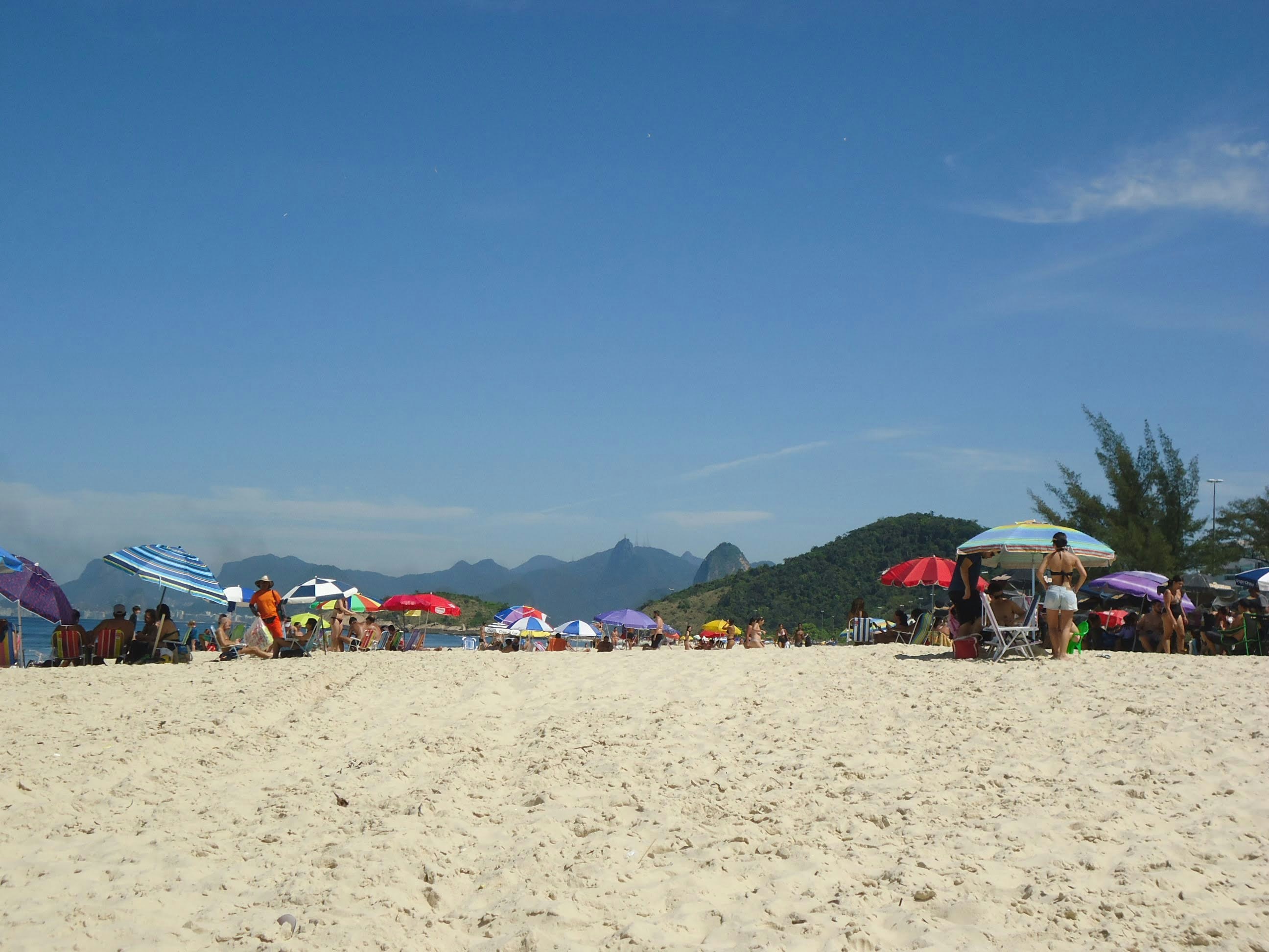 a group of people standing on top of a sandy beach