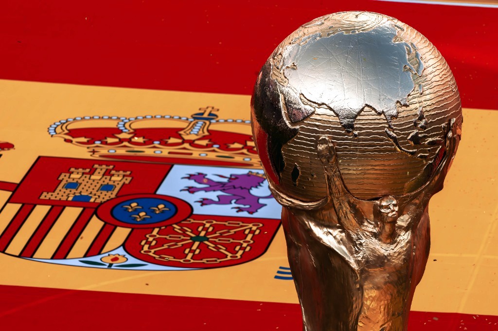 The FIFA World Cup trophy stands in front of a Spanish flag after Spain's 2026 title win
