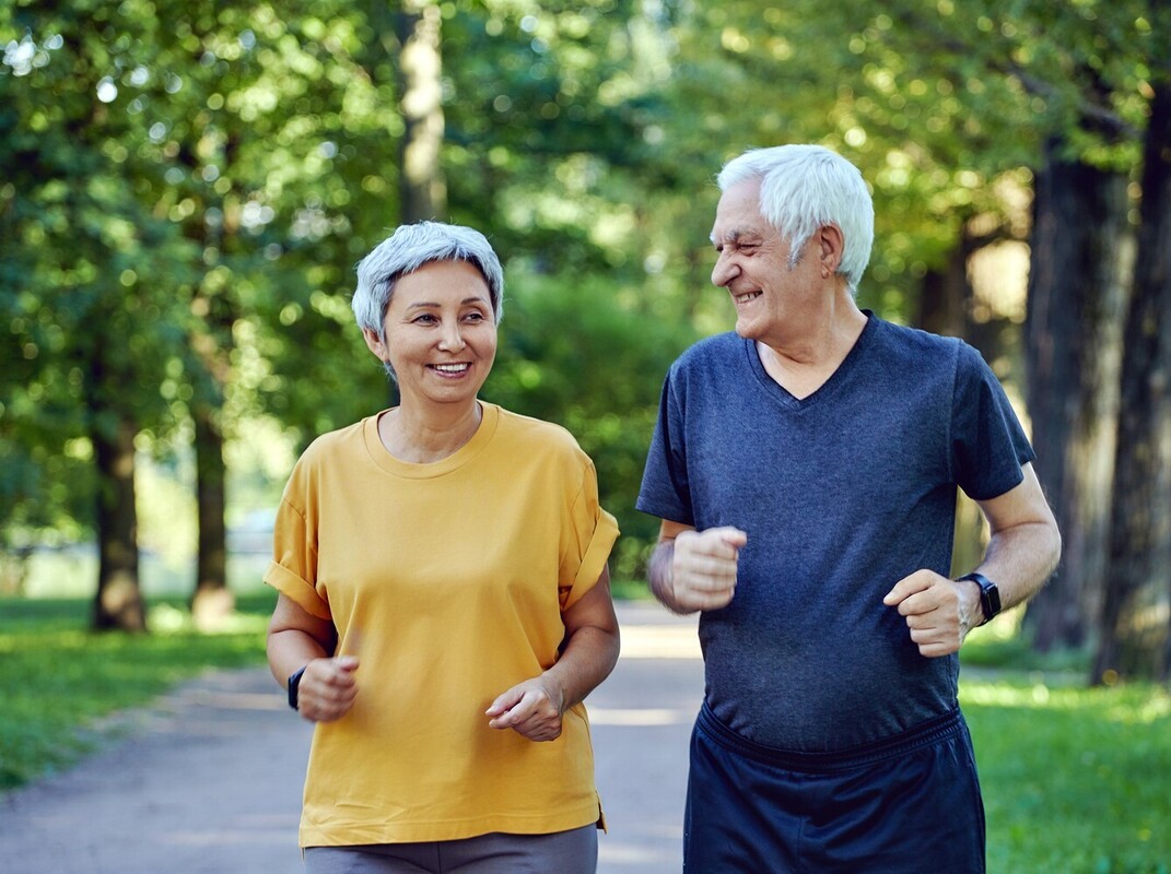 older couple learning how to lose weight with walking by following an easy route through a park