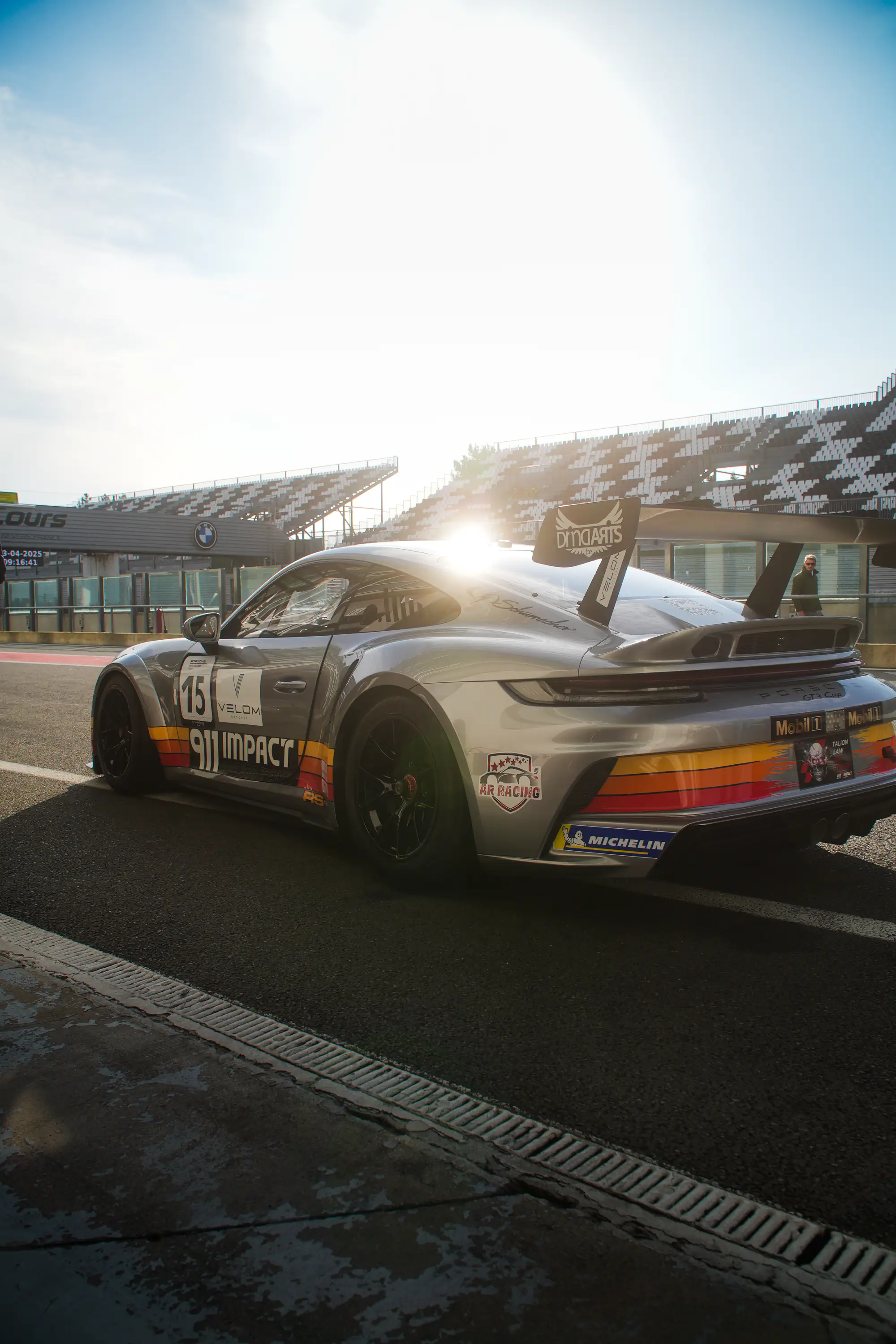 Porsche 911 de course numéro 15 aux couleurs 911 Impact près des tribunes, week-end GT3 Cup à Magny-Cours