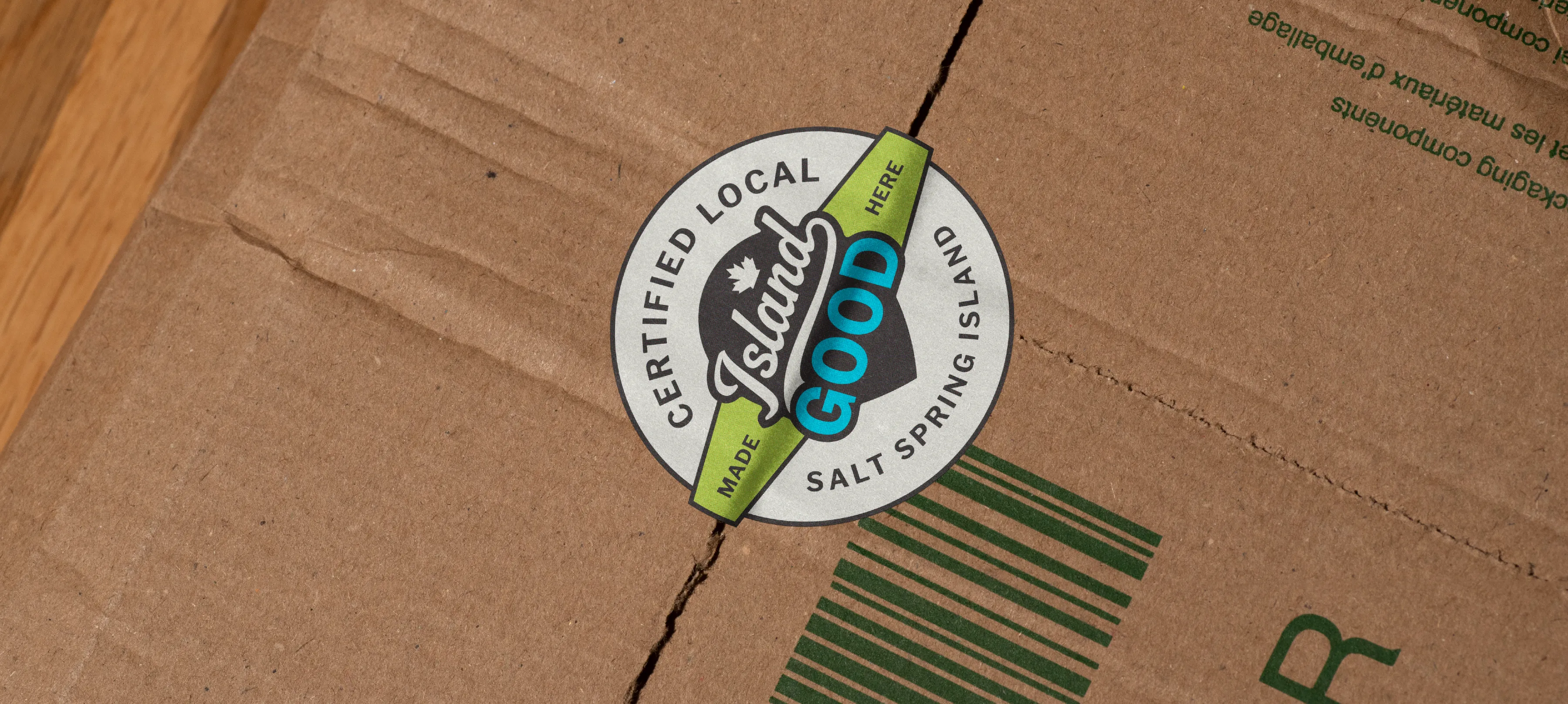 A certification badge sticker being used to seal a cardboard box.