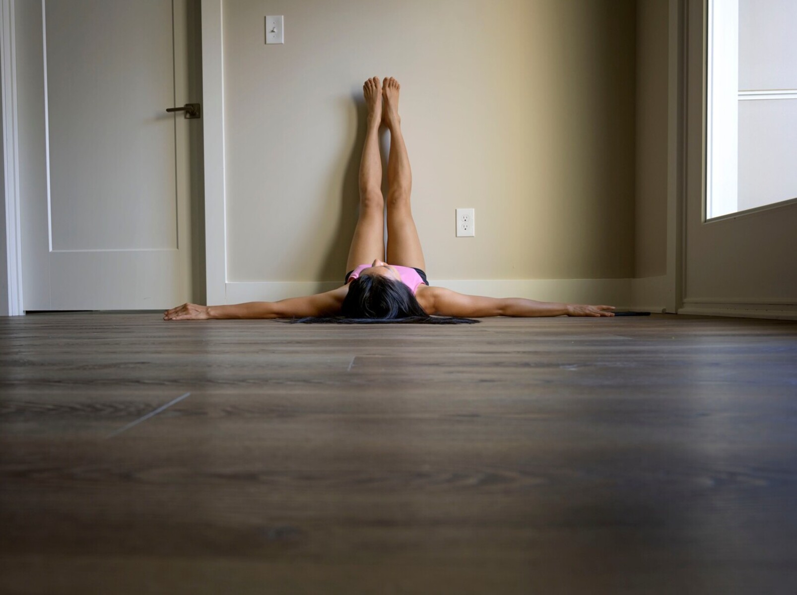 woman doing wall pilates to lose weight at home in her living room