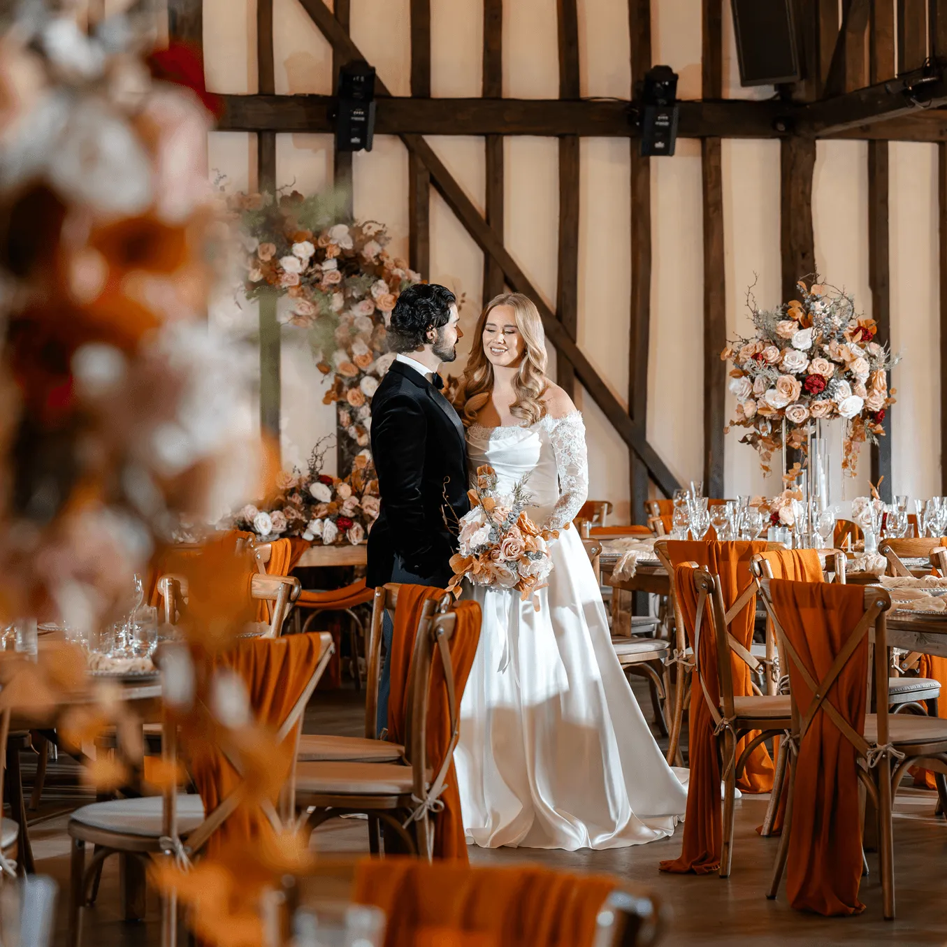 Wedding couple standing by floral decor.