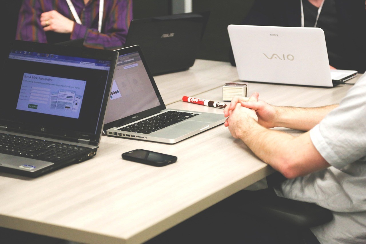 People seated around a table working on laptops during a meeting
