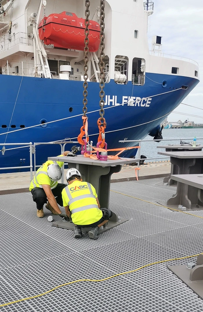 CASC engineers performing mechanical operations on offshore installation equipment at a quayside.