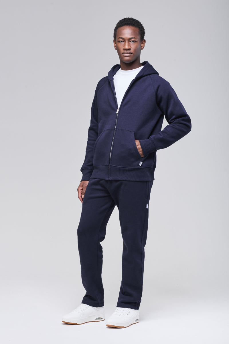 ale model wearing navy zip hoodie, hand in front pocket