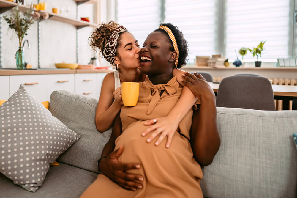 woman kissing pregnant partner's cheek
