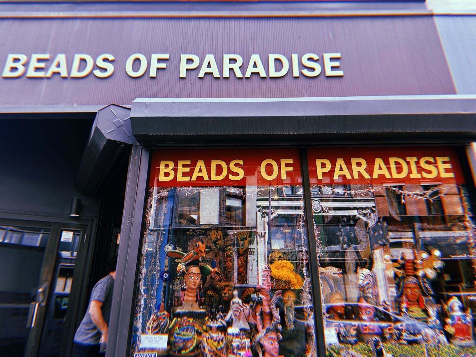 The Beads of Paradise storefront with colorful objects filling its windows.