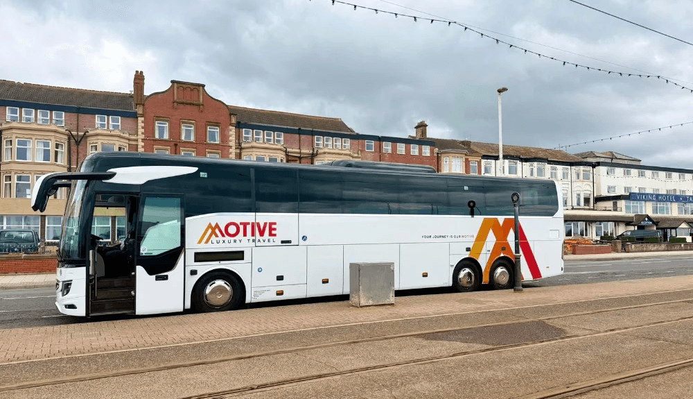 Luxury coach or minibus traveling through scenic landscapes, representing Motive’s professional chauffeur and transport services designed for comfort, reliability, and style.