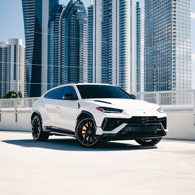 White Lamborghini Urus S for rent in Miami, front 3/4 view showcasing dynamic design, luxury SUV rental.
