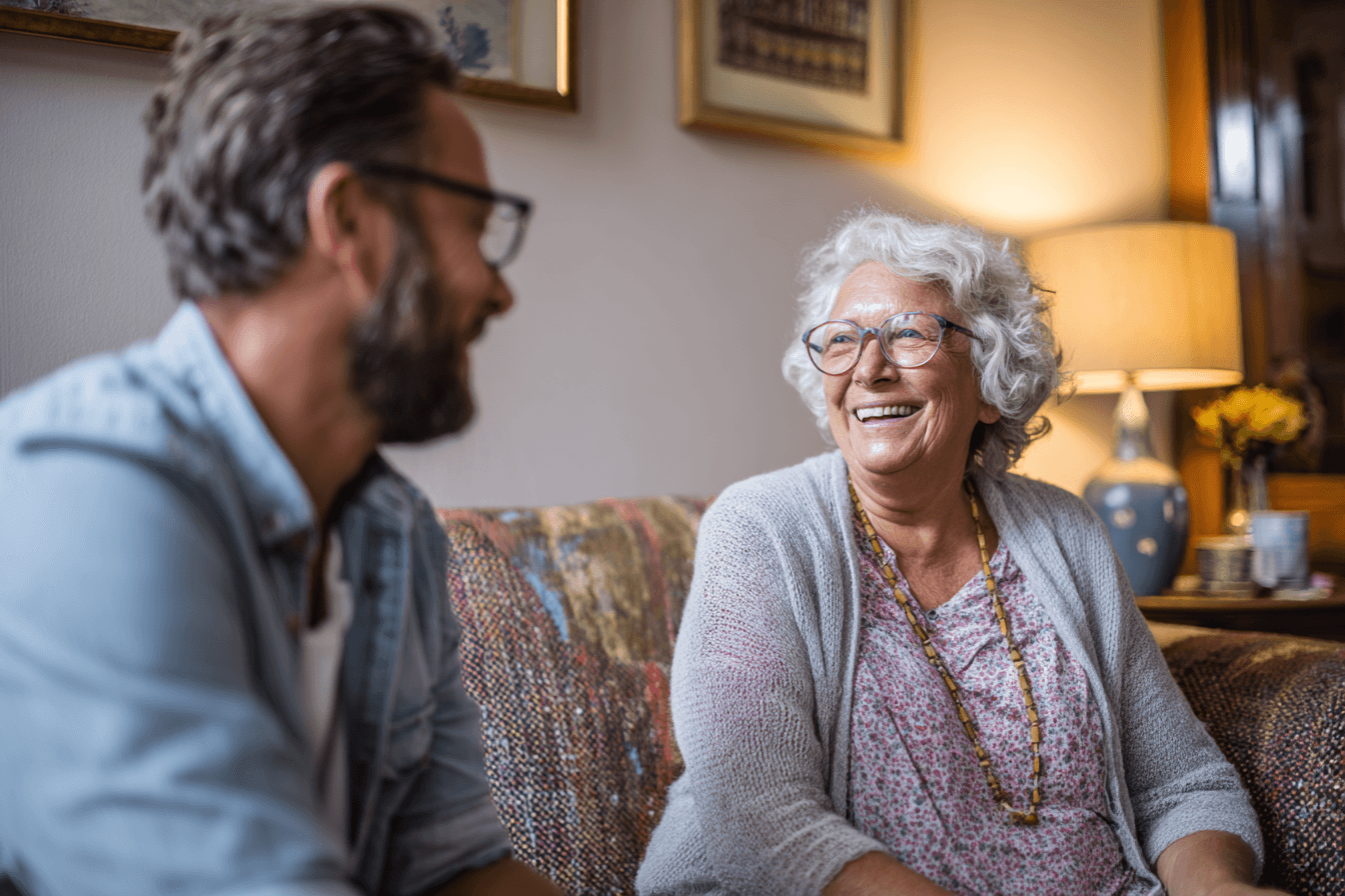 a home care agency operator (male, 50s), talking with an adult female in her elderly mother's home.