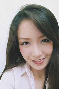 A photo of a smiling woman wearing a white shirt.