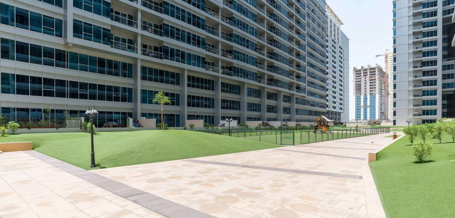 Landscaped communal garden and walkway at Skycourt Towers Dubai, an ideal amenity for prospective home buyers.
