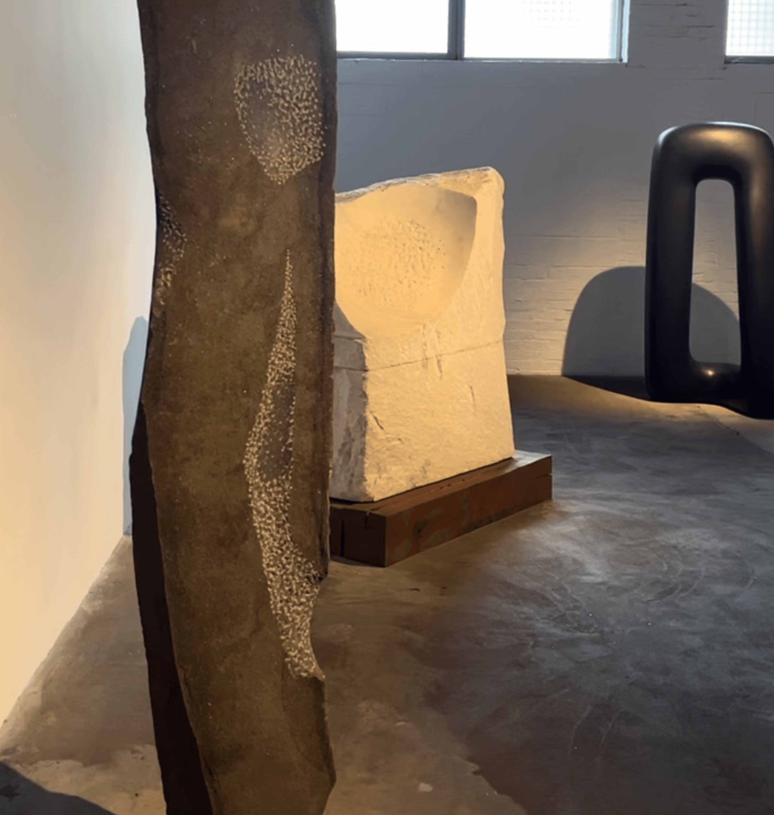 Interior gallery view at The Noguchi Museum featuring stone sculptures on concrete floor, Long Island City Queens