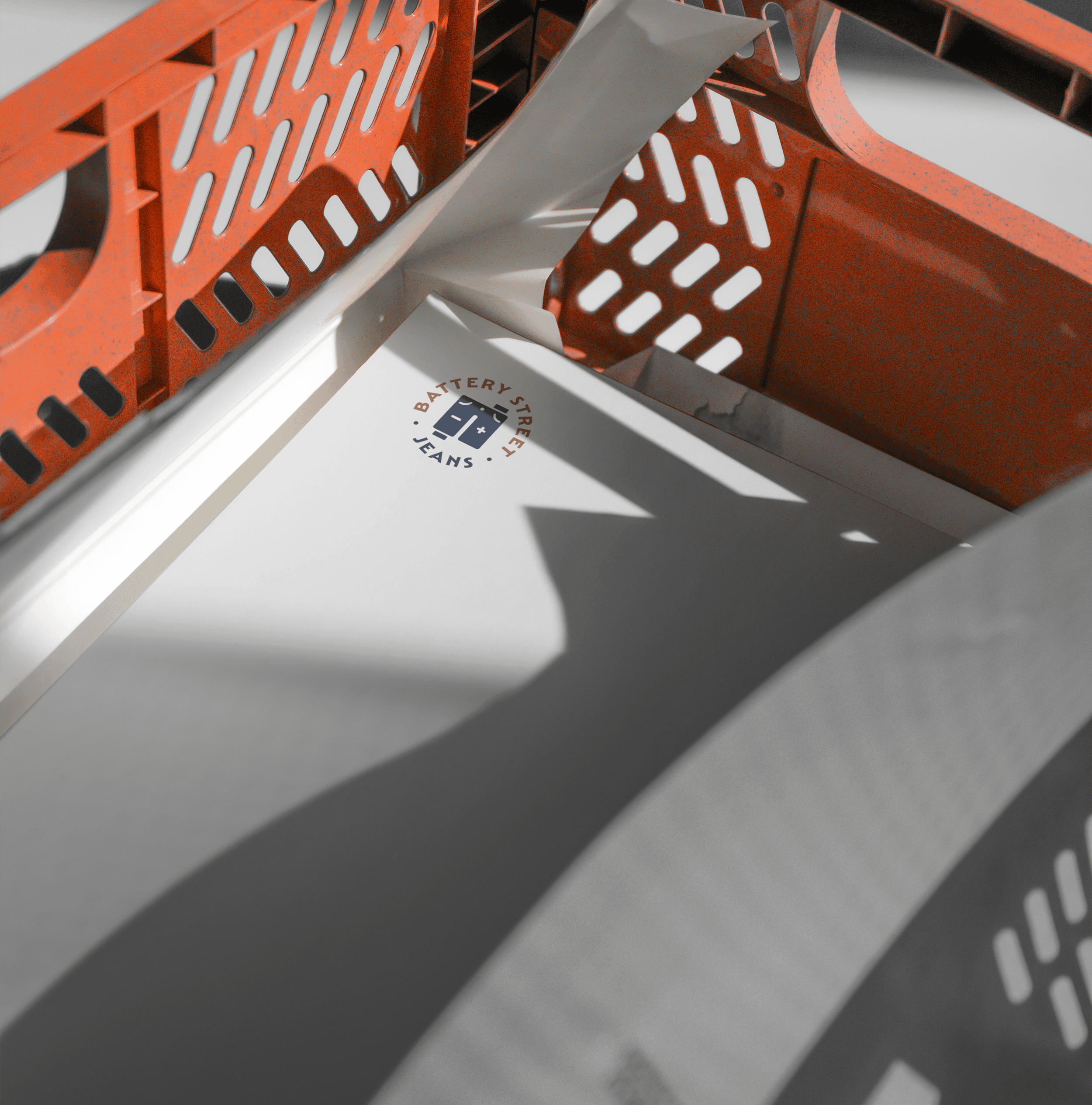 Orange plastic cart casts shadows on Battery Street Jeans letterheads 