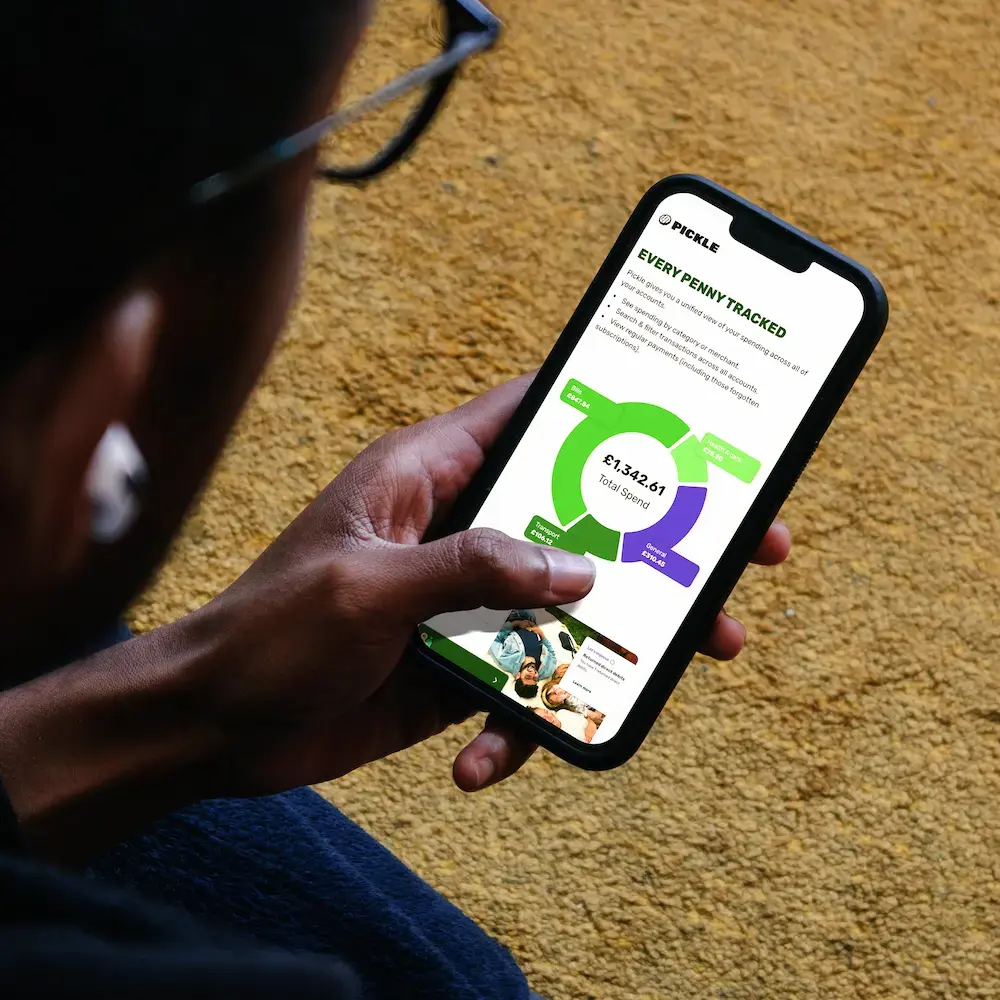 Pickle finance app UI design on iPhone — person holding smartphone displaying spending tracker dashboard with category breakdown and total spend visualisation