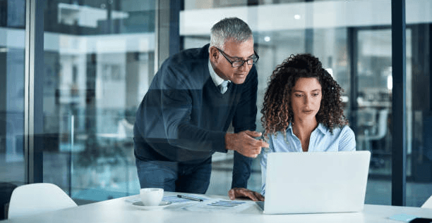 Two nonprofit professionals reviewing tools and resources together on a laptop