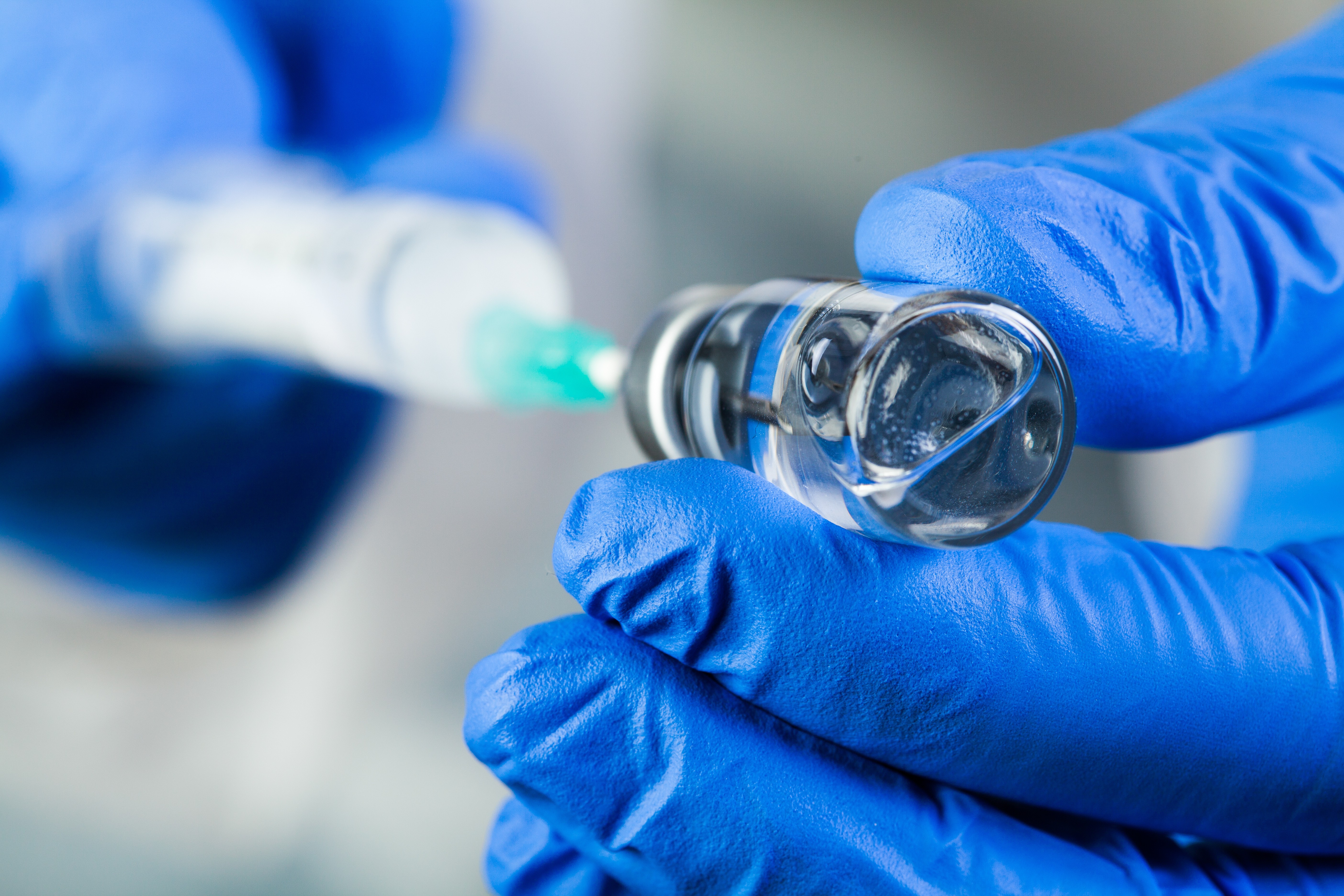A synige and needed inserted in a vial containing clear liquid.