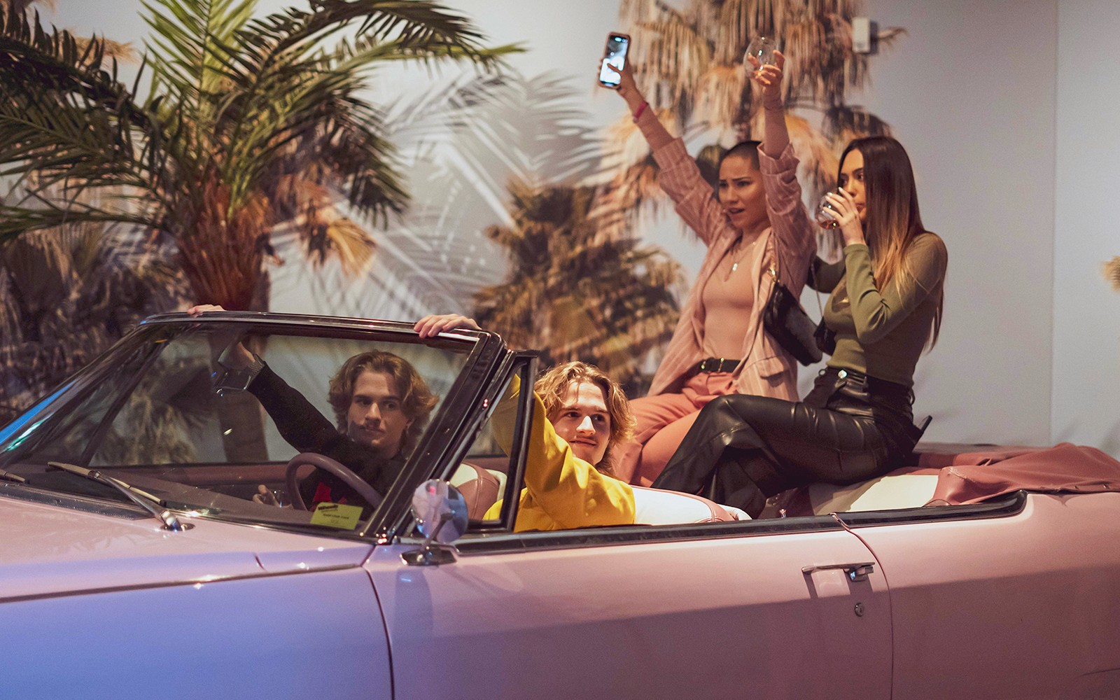 Látogatók élvezik az utazást egy rózsaszín kabrióban a Pink Palace-ban.