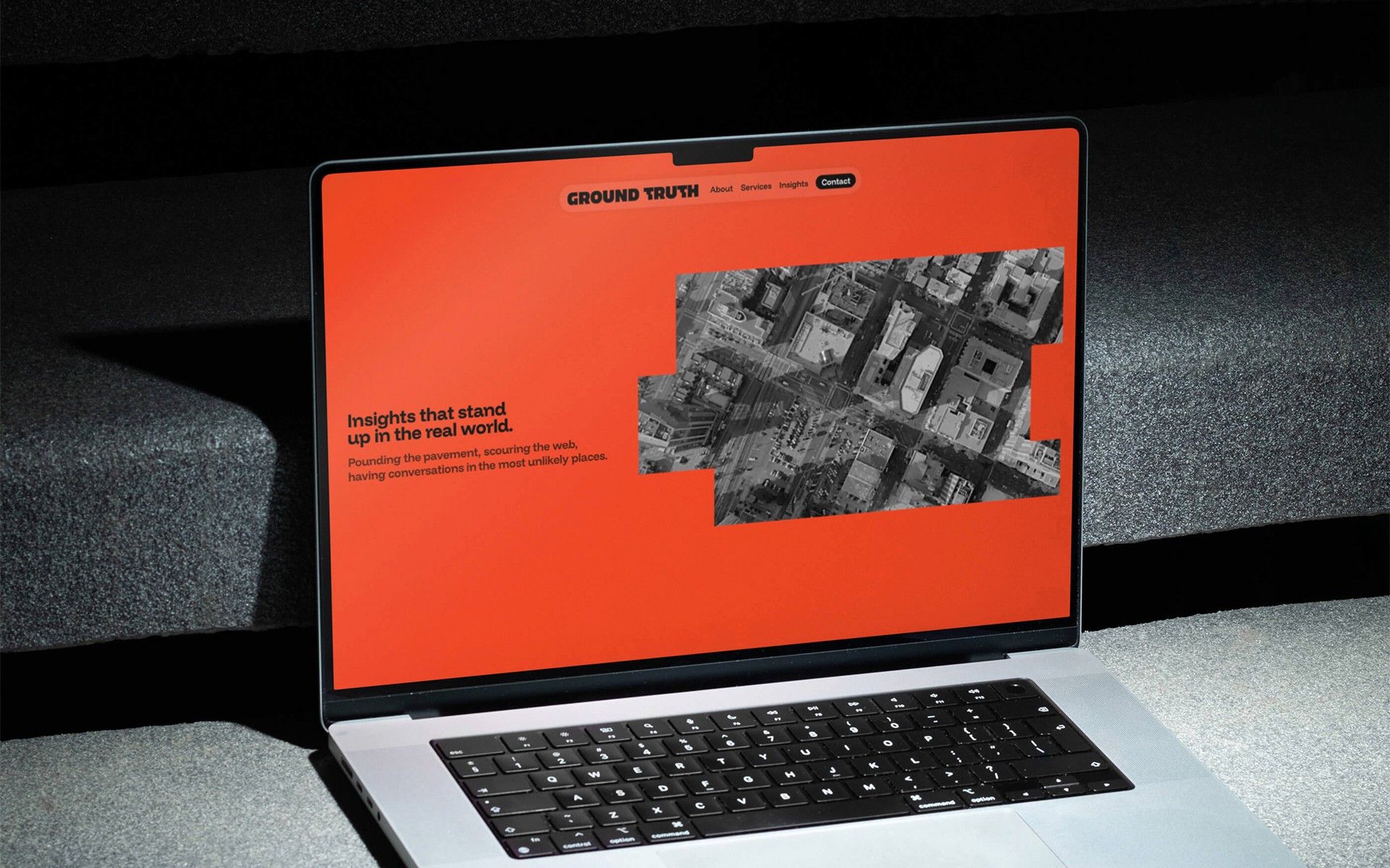 A laptop displaying an orange screen with a graphic, placed on a white surface.
