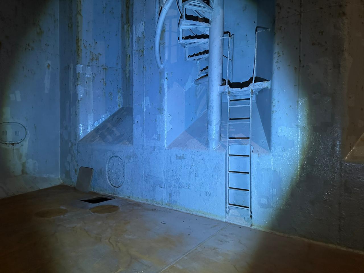 Cargo Hold 01 of UNIGLOBE during night holds inspection, illuminated by portable lights for cleanliness and suitability checks.