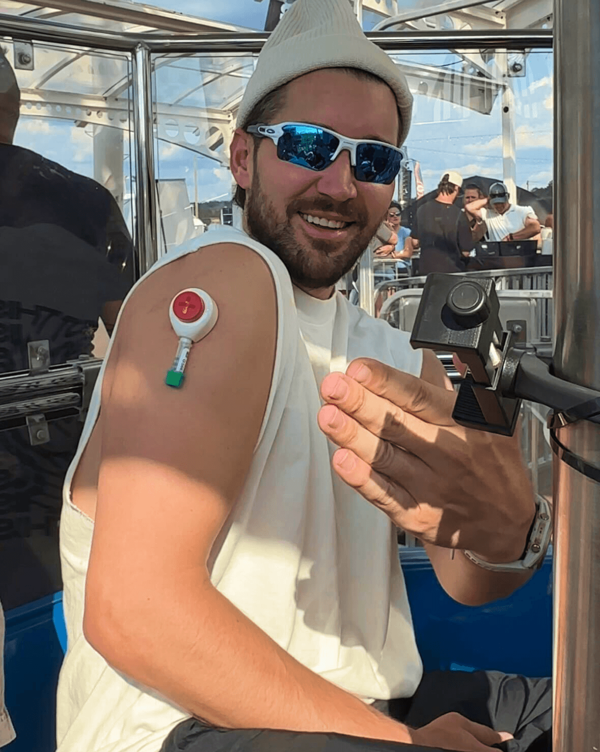 Portrait of Jeff, smiling doing a self collected blood test on a ferriswheel