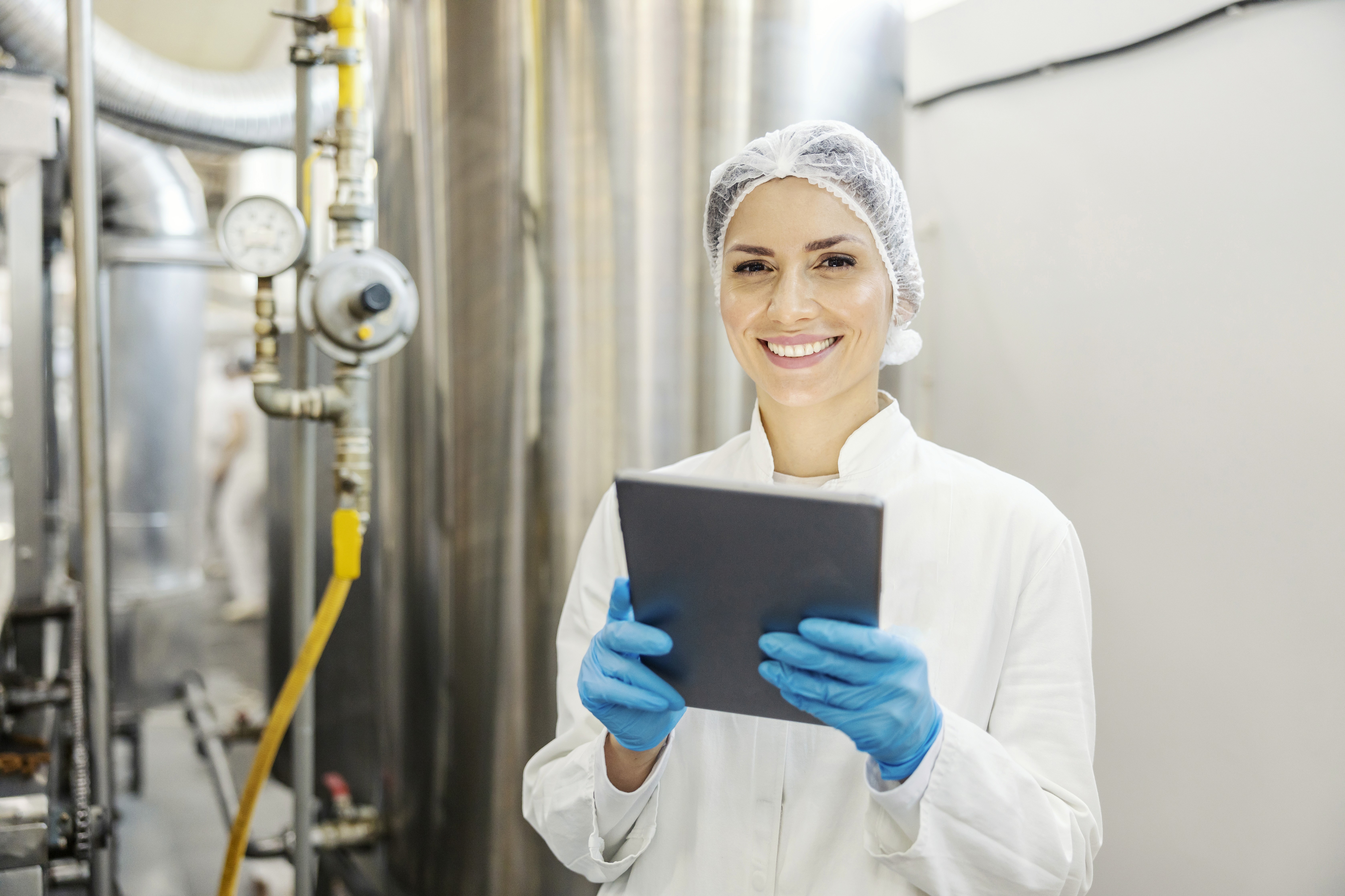 Trabalhador em uma área de mineração utilizando EPIs e segurando um tablet nas mãos