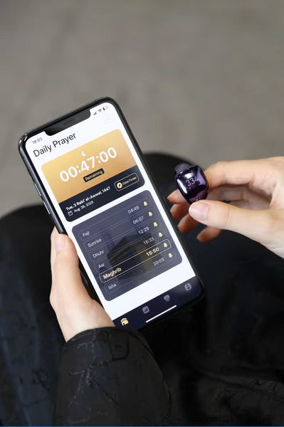 Muslim using smartphone Salah reminder app with tasbih ring