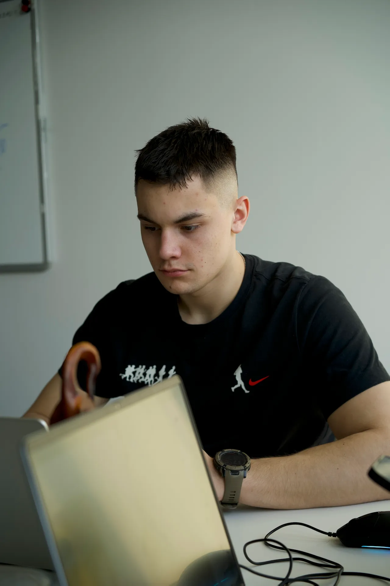 Portrait of a laughing person with curly hair wearing a white shirt
