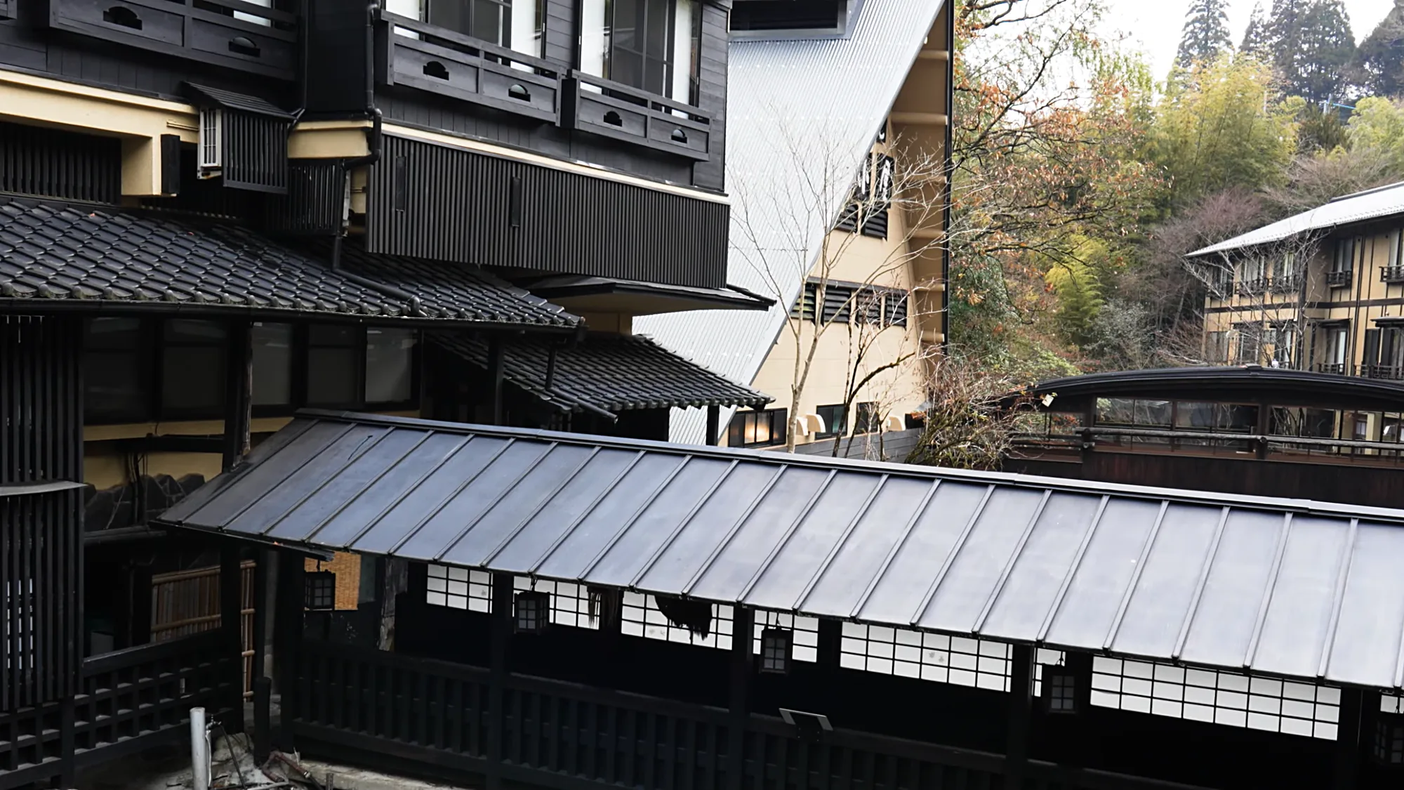 Dark timber inns standing above the covered walkway at Kurokawa Onsen