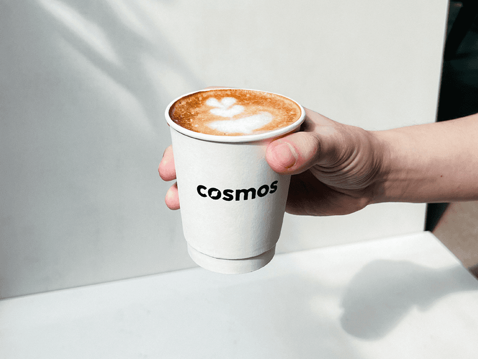 Cosmos Coffee wordmark applied on a coffee cup.