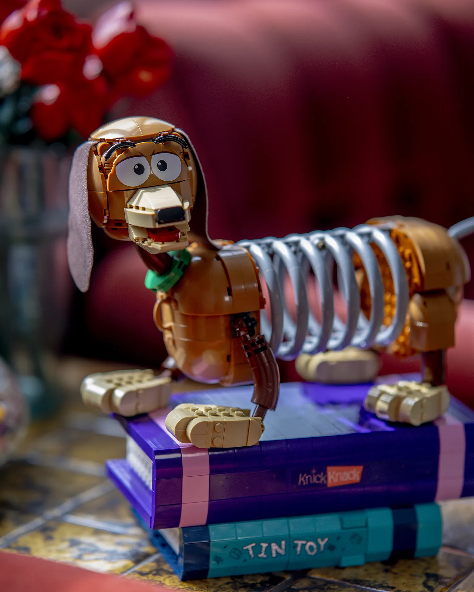 Nærbilde av LEGO Toy Story-modellen Slinky Dog stående på to LEGO-bøker
