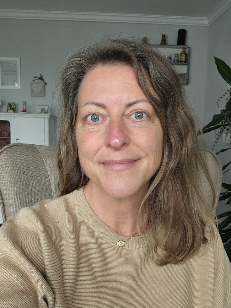 a woman sitting on a white chair next to a table
