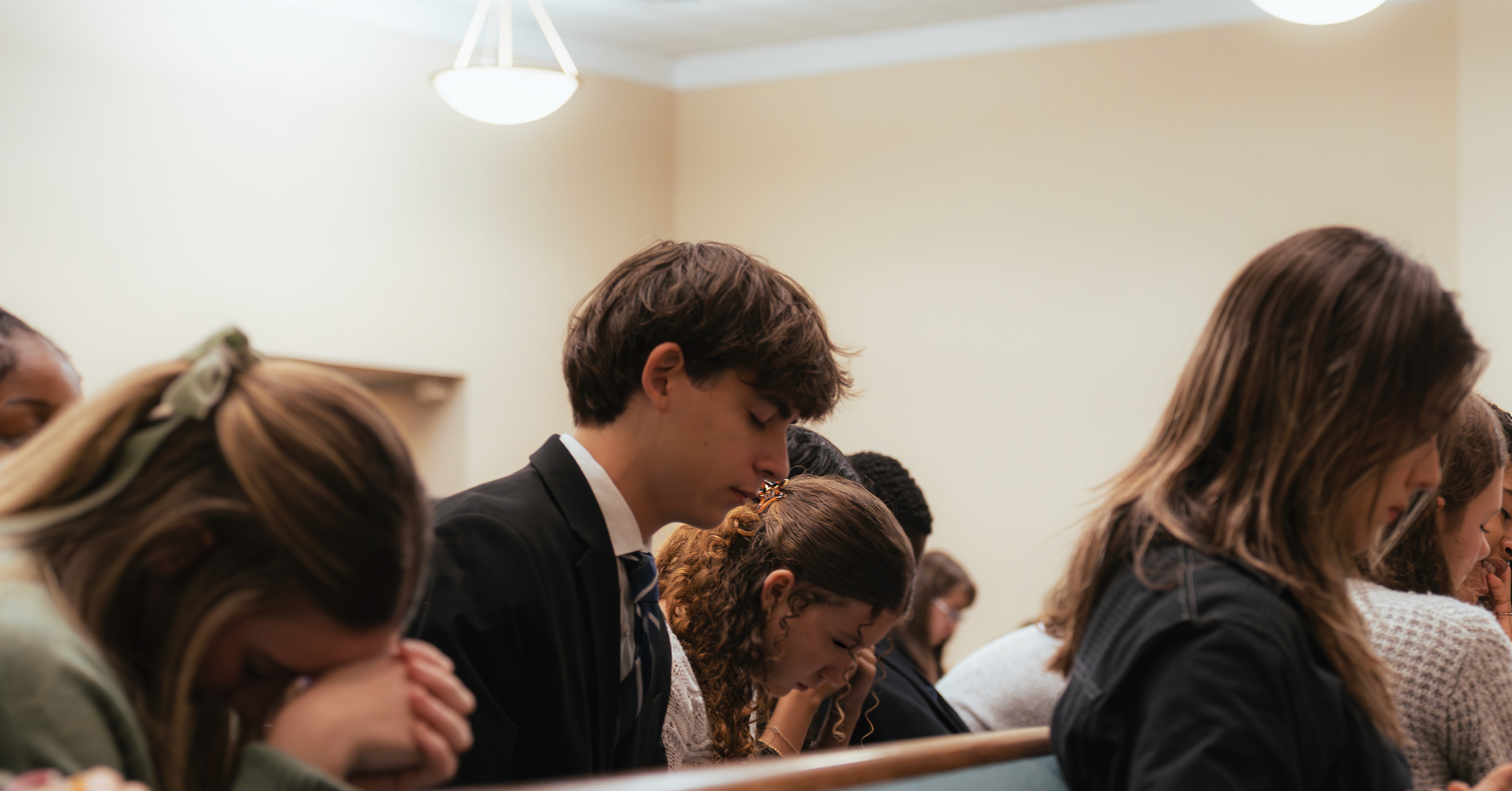 Student praying during our honor society ceremony