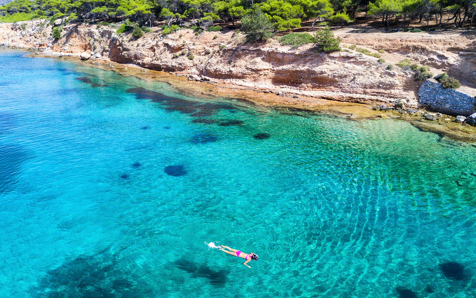 Nurek eksplorujący czyste wody w pobliżu skalistego wybrzeża wyspy Aegina, Grecja.